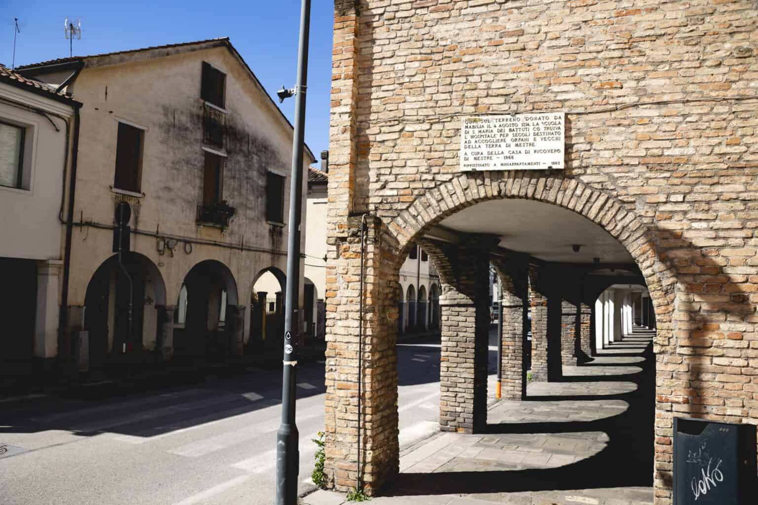 Gli antichi porticati dell'Hospitale dei Battuti e la targa che ricorda la donazione di Mabilia del 1314 (Anna Motterle)