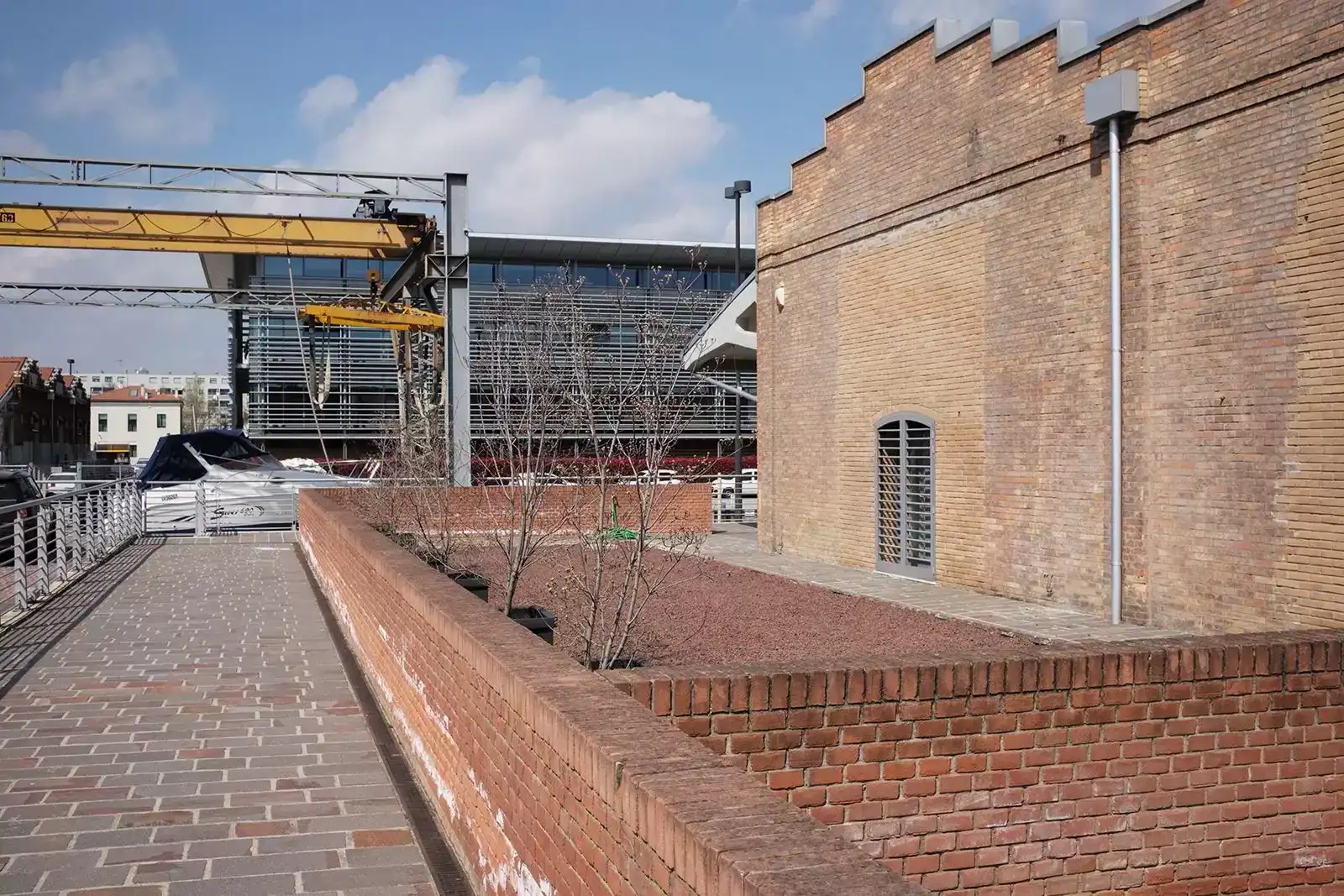 Uno scorcio con un edificio ex magazzino, la darsena e il Laguna Palace