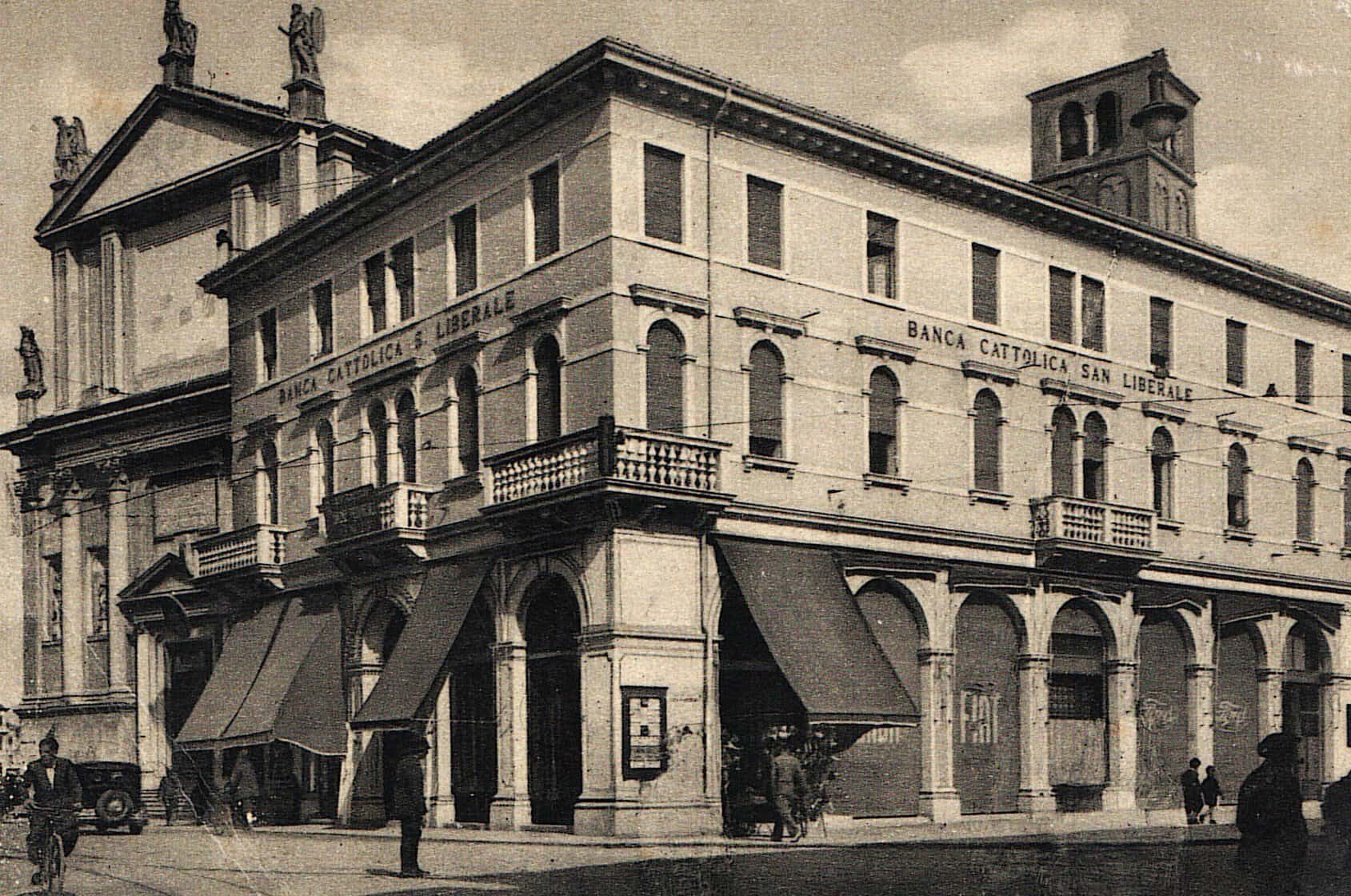 Il palazzo della Banca Cattolica San Liberale accanto al duomo di San Lorenzo, in una cartolina d'epoca