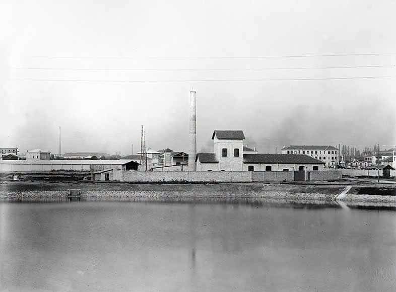 Lo stabilimento Sorgato per la distillazione dei catrami a Porto Marghera, con la ciminiera, visto dall'acqua del canale
